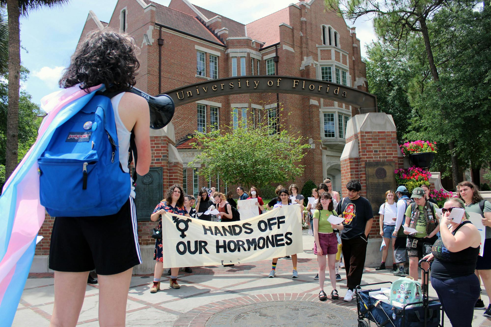 Protestors for transgender access to healthcare gather at the corner of University Avenue and 13th Street to begin a march toward the Student Health Care Center where some will perform an “inject-in” of HRT Friday, April 7, 2023.