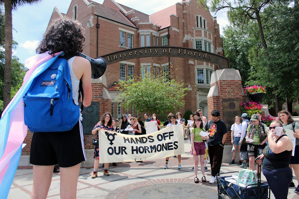 <p>Protestors for transgender access to healthcare gather at the corner of University Avenue and 13th Street to begin a march toward the Student Health Care Center where some will perform an “inject-in” of HRT Friday, April 7, 2023.</p>
