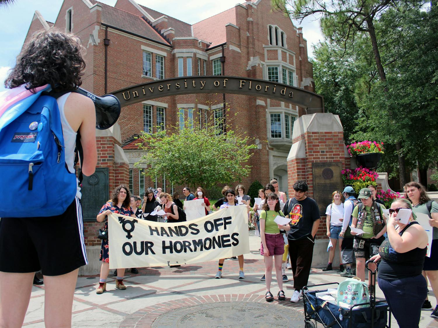 Protestors for transgender access to healthcare gather at the corner of University Avenue and 13th Street to begin a march toward the Student Health Care Center where some will perform an “inject-in” of HRT Friday, April 7, 2023.