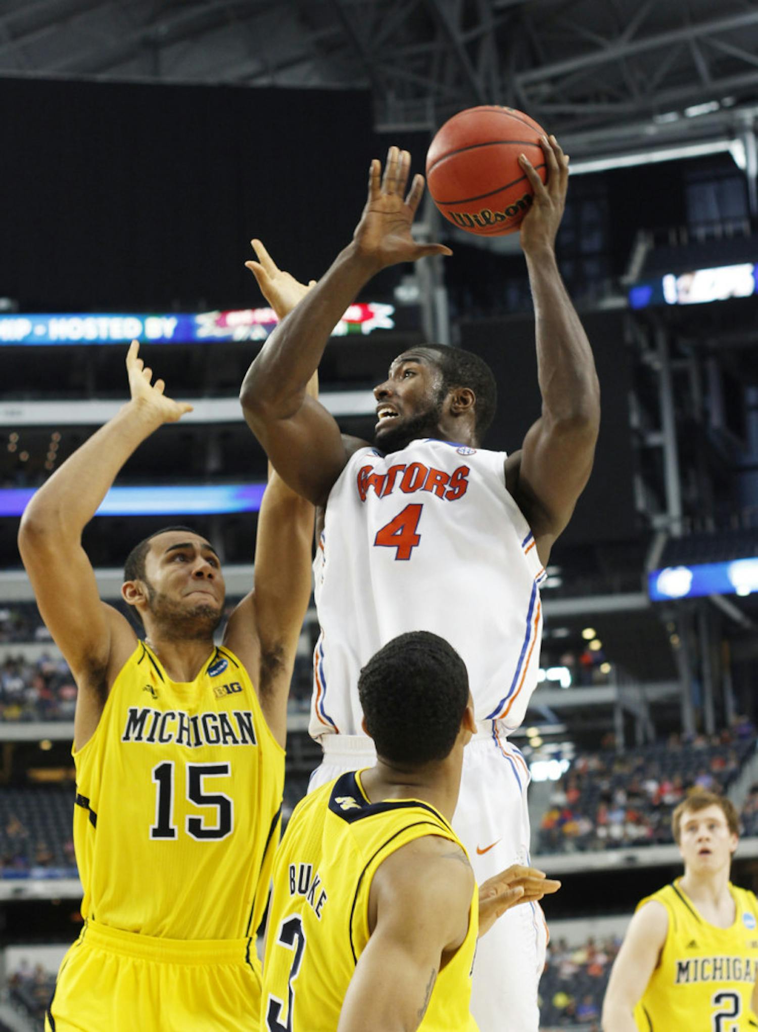 Junior center Patric Young (4) attempts a shot during Florida’s 79-59 loss to Michigan in the Elite Eight on Sunday at Cowboys Stadium in Arlington, Texas.