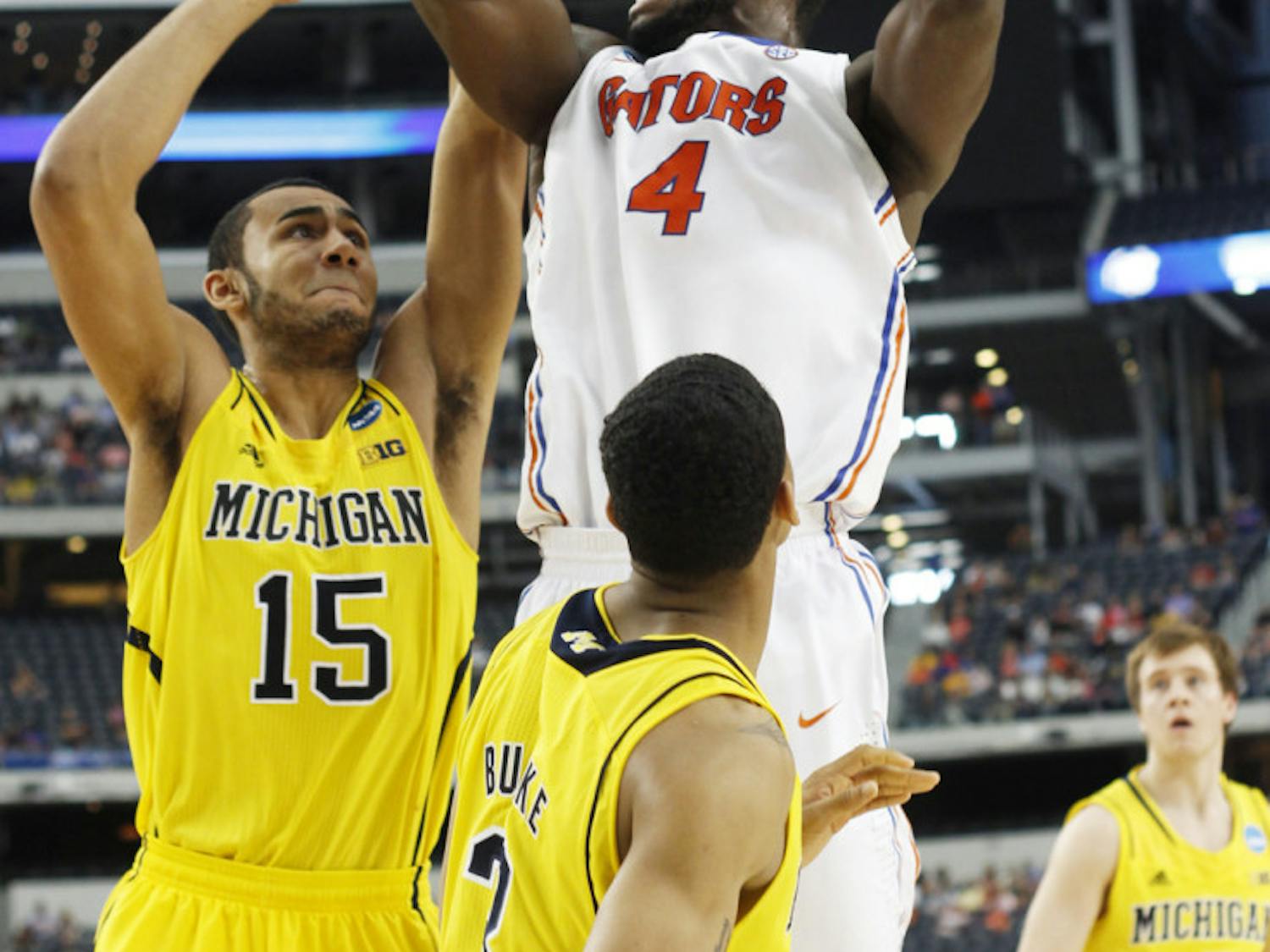 Junior center Patric Young (4) attempts a shot during Florida’s 79-59 loss to Michigan in the Elite Eight on Sunday at Cowboys Stadium in Arlington, Texas.