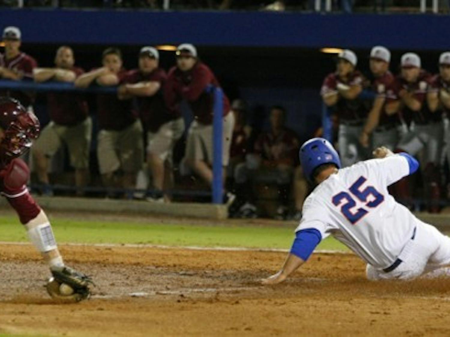 Preston Tucker (25) slides past FSU catcher Stephen McGee during UF’s home win March 13. The two top-five teams meet again tonight at 7 at The Baseball Grounds of Jacksonville.