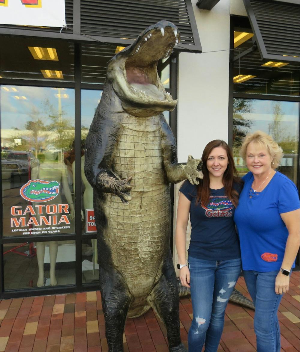 <p>Lisa Blum and Jenice Bushnell stand in front of Gator Mania with their 12-foot fiberglass alligator. [Photo courtesy of Lisa Blum]</p>