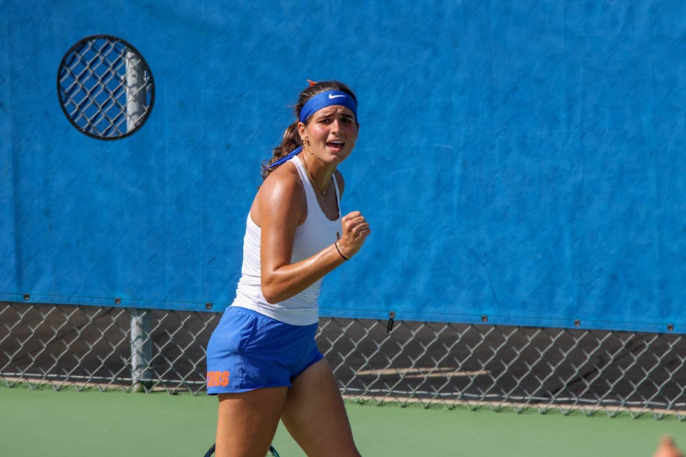 Gators sophomore Emily De Oliveira celebrates after winning a point in a 4-1 victory against the Michigan Wolverines Wednesday, March 22, 2023.