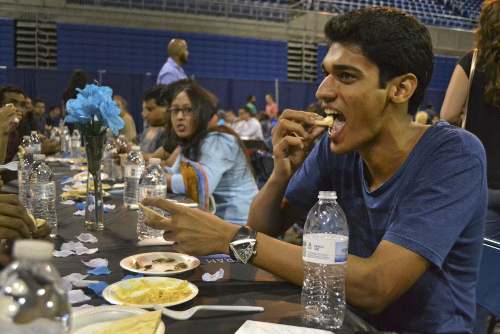 Mickey Vellukunnel, a 26-year-old UF computer science graduate student, breaks his fast with pita bread and hummus. He said the space was a good way for people of different religions to come together and “get a taste of the practice,” an Islamic tradition to cleanse one’s body and spirit.