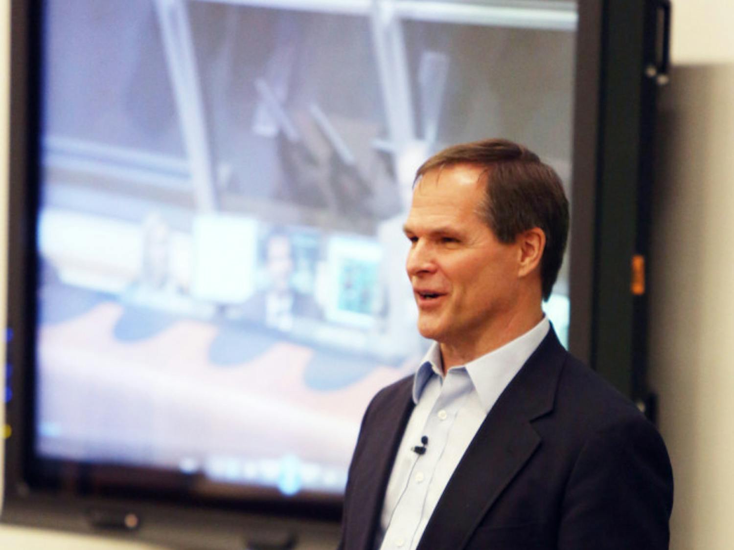 Retired astronaut Kevin Ford presents an Expedition 34 mission patch that was flown in space.