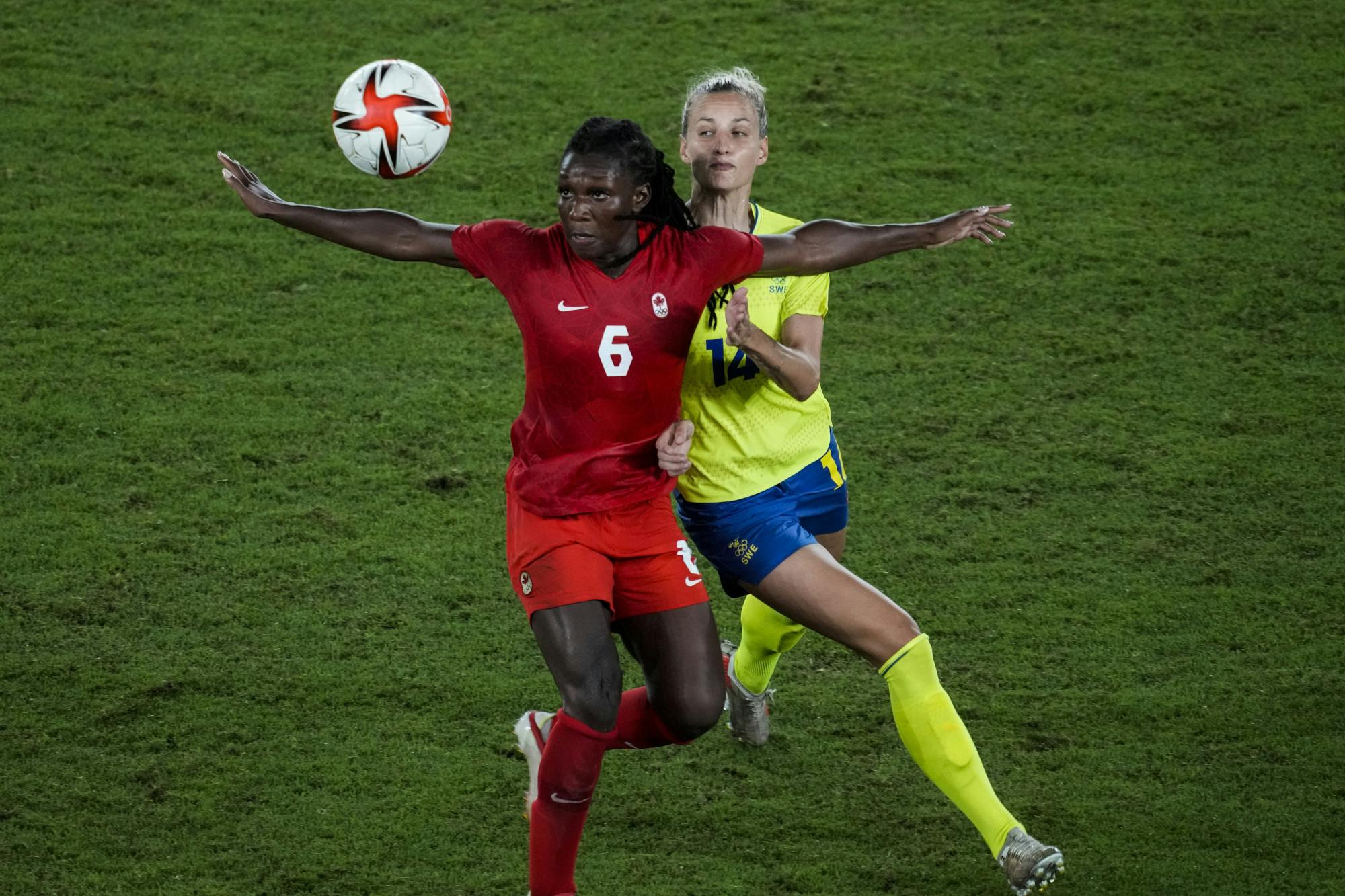 Canada's Deanne Rose duels for the ball with Sweden's Nathalie Bjorn during the women's final soccer match at the 2020 Summer Olympics, Friday, Aug. 6, 2021, in Yokohama, Japan. (AP Photo/Kiichiro Sato)