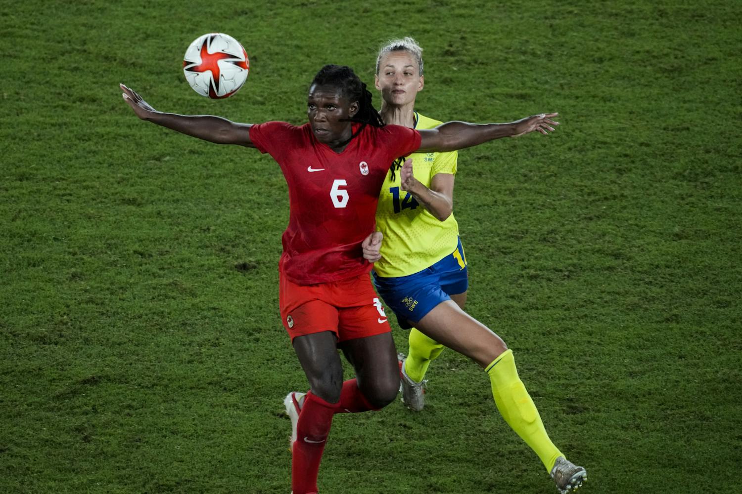 Canada's Deanne Rose duels for the ball with Sweden's Nathalie Bjorn during the women's final soccer match at the 2020 Summer Olympics, Friday, Aug. 6, 2021, in Yokohama, Japan. (AP Photo/Kiichiro Sato)