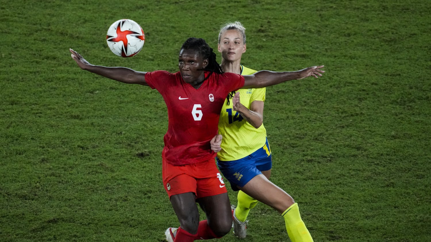 Canada's Deanne Rose duels for the ball with Sweden's Nathalie Bjorn during the women's final soccer match at the 2020 Summer Olympics, Friday, Aug. 6, 2021, in Yokohama, Japan. (AP Photo/Kiichiro Sato)