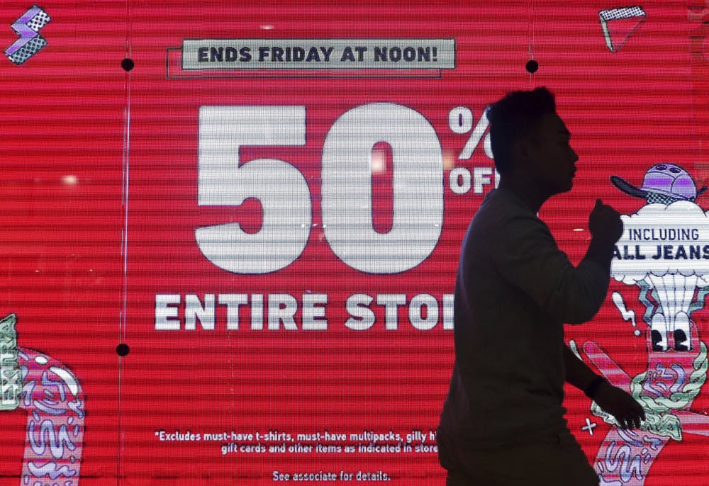 A shopper passes in front of a large advertisement on Black Friday at the Fox River Mall on Friday, Nov. 29, 2019, in Grand Chute, Wis. (Wm. Glasheen/The Post-Crescent via AP)