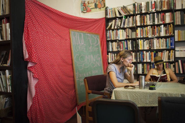 Gretchen Mcintyre, 30, left, and Katie Conly, 30, read at the Civic Media Center on Monday. The Radical Press Coffee Collective, an independent vegan coffee shop, is scheduled to open there in March, store owner Rusti Poulette said.