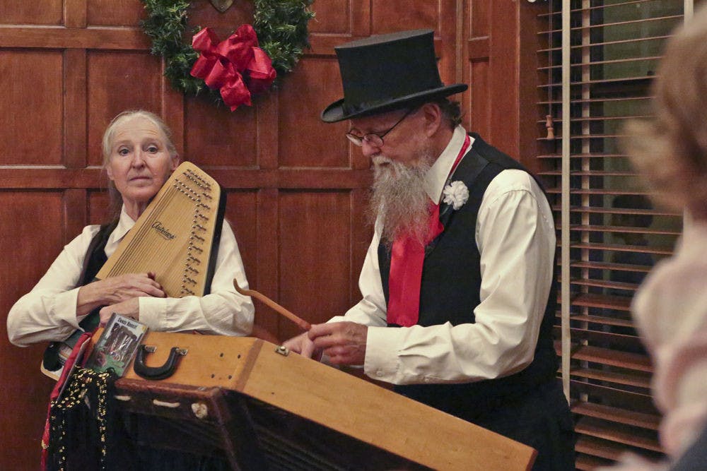 Joyce Lillquist plays the chorded zither while her husband, Jim, plays the hammer dulcimer during the annual Holiday Tree Lighting ceremony at the Historic Thomas Center on Dec. 5, 2015. The Gypsy Guerrilla Band, composed of the couple, performed a variety of holiday tunes.
