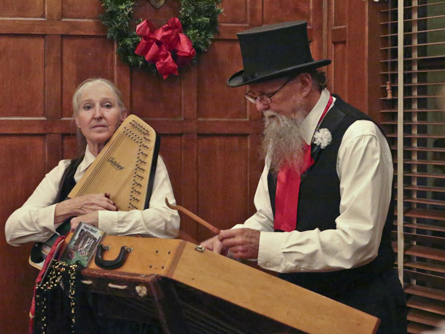 Joyce Lillquist plays the chorded zither while her husband, Jim, plays the hammer dulcimer during the annual Holiday Tree Lighting ceremony at the Historic Thomas Center on Dec. 5, 2015. The Gypsy Guerrilla Band, composed of the couple, performed a variety of holiday tunes.