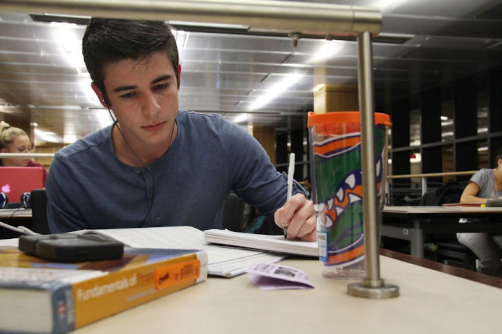 <p class="p1">Nick Arena, a 19-year-old UF accounting freshman, reads a textbook at Library West on Monday afternoon.</p>