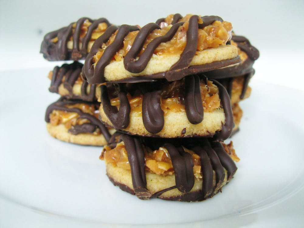 <p>Samoas are simple shortbread cookies with a hole in the center,
covered in a caramel and toasted coconut topping and then dipped in
and streaked with rich dark chocolate.</p>