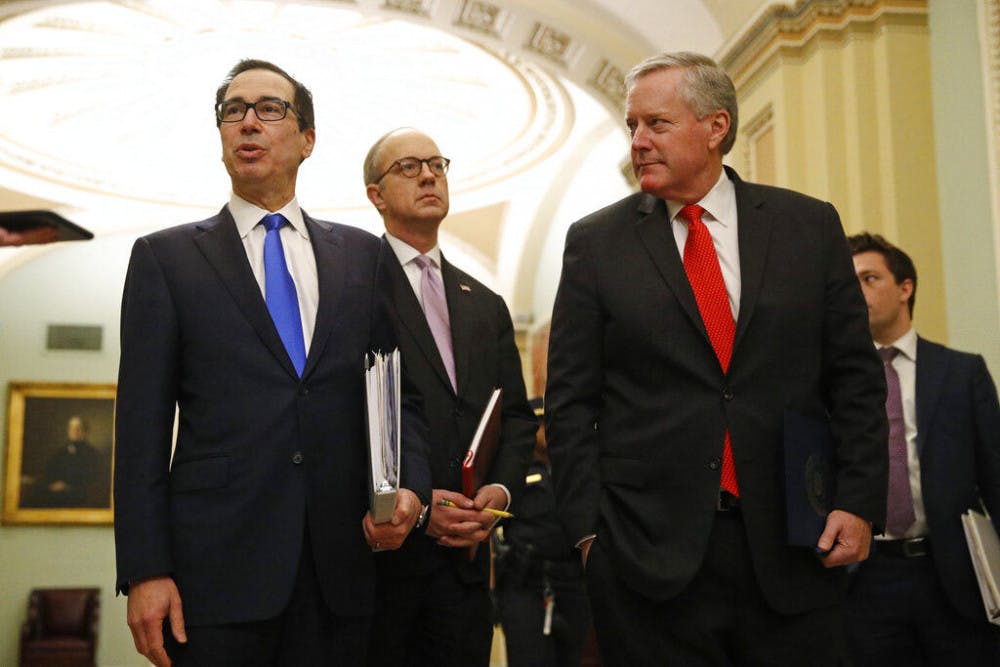 <p>Treasury Secretary Steven Mnuchin, left, accompanied by White House Legislative Affairs Director Eric Ueland and acting White House chief of staff Mark Meadows, speaks with reporters as he walks to the offices of Senate Majority Leader Mitch McConnell of Ky. on Capitol Hill in Washington, Tuesday, March 24, 2020. (AP Photo/Patrick Semansky)</p>
