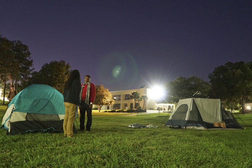 <p>Clarinda Choice (left), a 29-year-old Santa Fe student leadership and activity specialist, and Jacobi Bedenfield, a 19-year-old Santa Fe agriculture freshman, chat under Santa Fe's "Oak Grove" late Nov. 23, 2015. Choice and Bedenfield were two of the five participants raising awareness for homelessness by camping overnight at the college.</p>