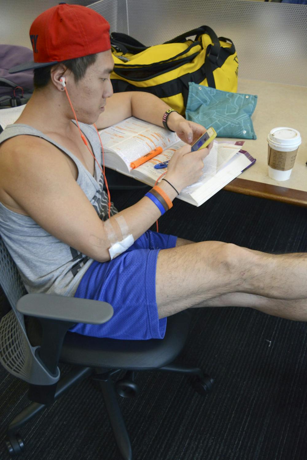 <p>Thomas Sit, a 24-year-old UF public health graduate student, takes a break from his work to use his smartphone in Library West on Sunday. Sit said he probably accessed the internet more on his phone than his laptop, mainly because the phone was more convenient for him.</p>