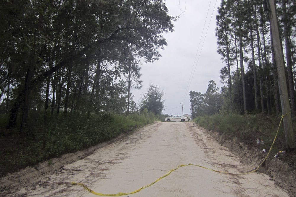 A police car blocks off the road to the home of Don Spirit on Friday afternoon. Spirit shot and killed his daughter and six grandchildren at his home before killing himself in Bell, Florida.