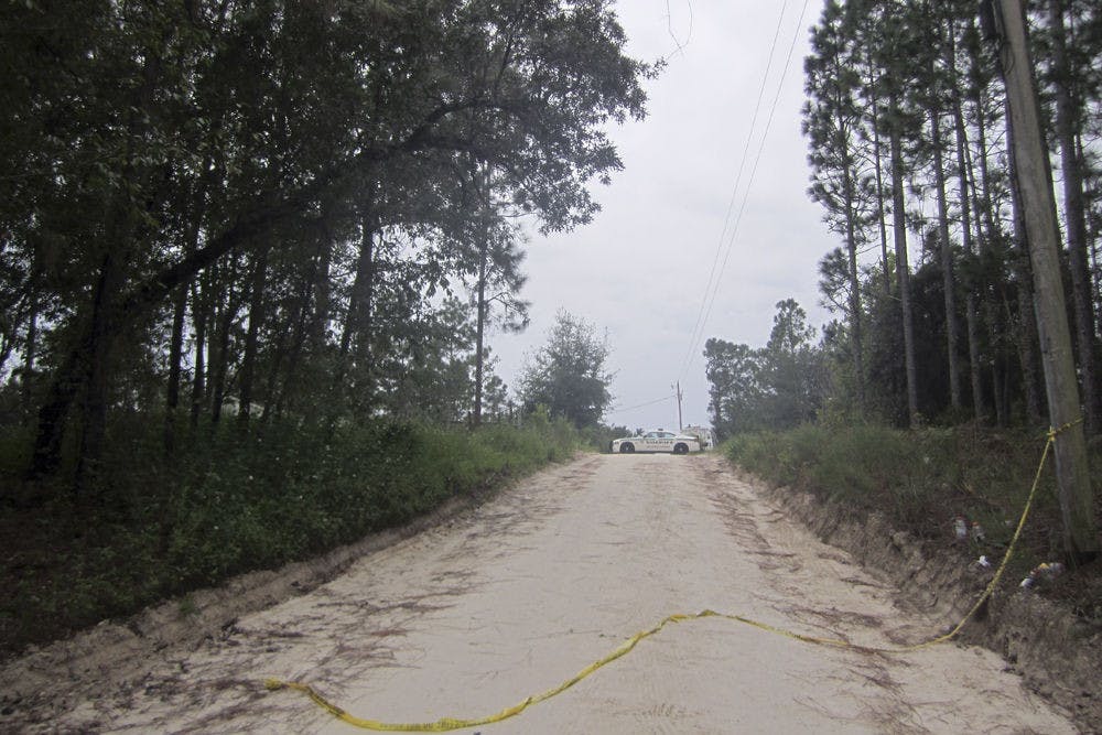 <p class="p1">A police car blocks off the road to the home of Don Spirit on Friday afternoon. Spirit shot and killed his daughter and six grandchildren at his home before killing himself in Bell, Florida.</p>