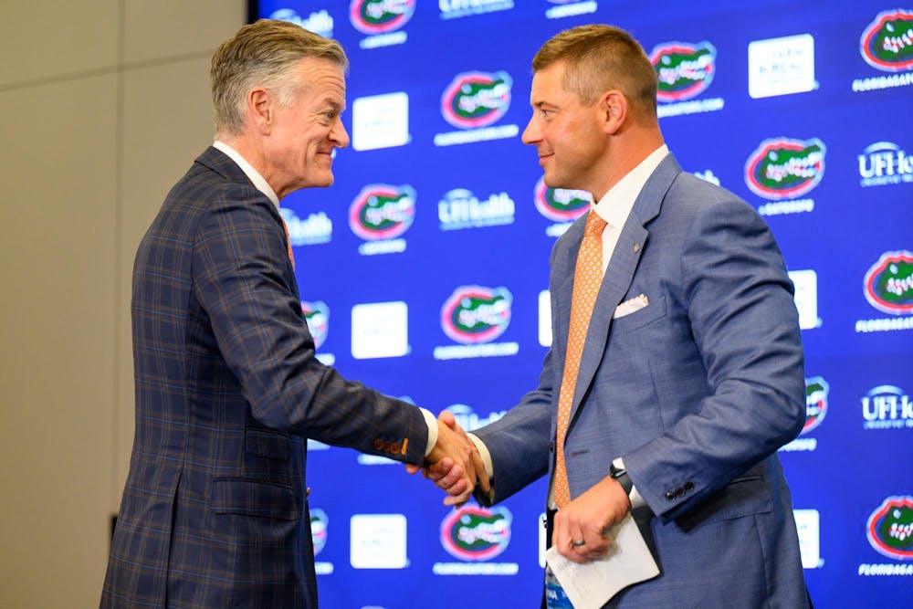 UF’s Athletics Director, Scott Stricklin, shakes Florida head coach Jon Sumrall hand after his introductory press conference at Heavener Football Training Center in Gainesville, Fla., Monday, Dec. 1, 2025.