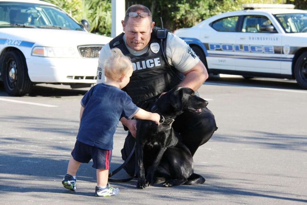 <p class="p1"><span class="s1">Gainesville Police School Resource Officer and K-9 Handler Mike Denmark meets 1-year-old Brody Joyce at the Gainesville Police Department on Wednesday during the Celebrate Safe Communities event. </span></p>