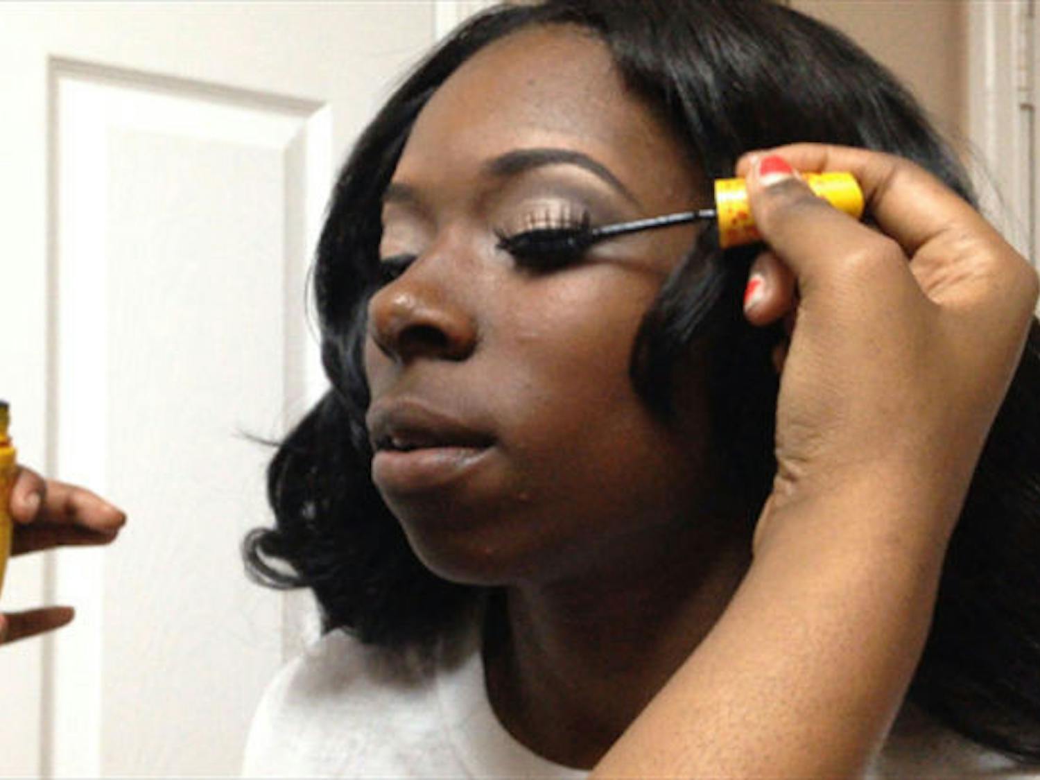 Kenya Tolbert gets her make-up done by 21-year-old advertising junior Stephany Jones. Tolbert won a complete makeover for her senior prom at Eastside High School.