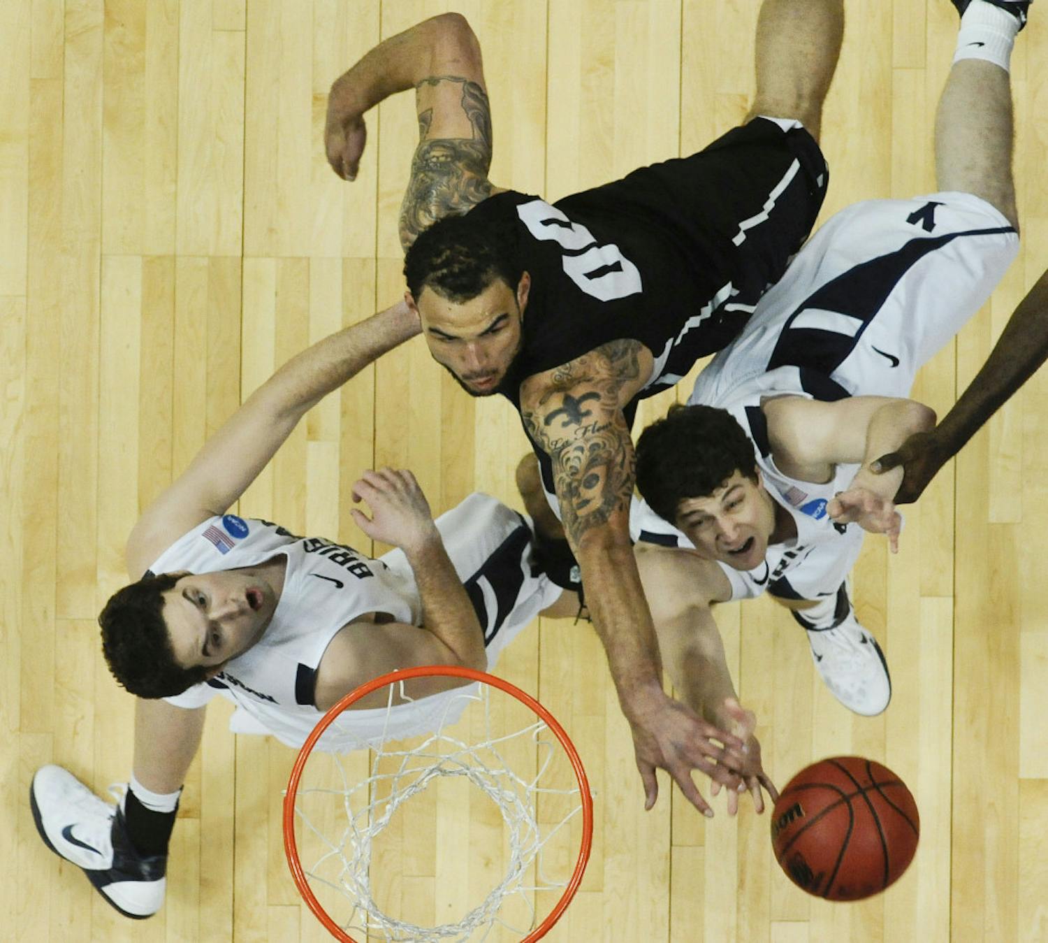 BYU's Jimmer Fredette, right, puts up a shot against Gonzaga's Robert Sacre, center, as Logan Magnusson looks on in the second half of a Southeast regional third round NCAA tournament college basketball game, Saturday, March 19, 2011, in Denver. (AP Photo/Jack Dempsey)
