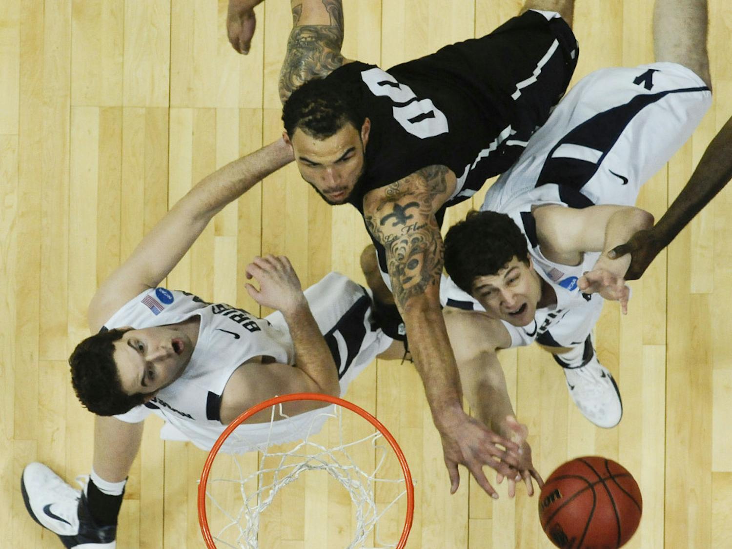 BYU's Jimmer Fredette, right, puts up a shot against Gonzaga's Robert Sacre, center, as Logan Magnusson looks on in the second half of a Southeast regional third round NCAA tournament college basketball game, Saturday, March 19, 2011, in Denver. (AP Photo/Jack Dempsey)