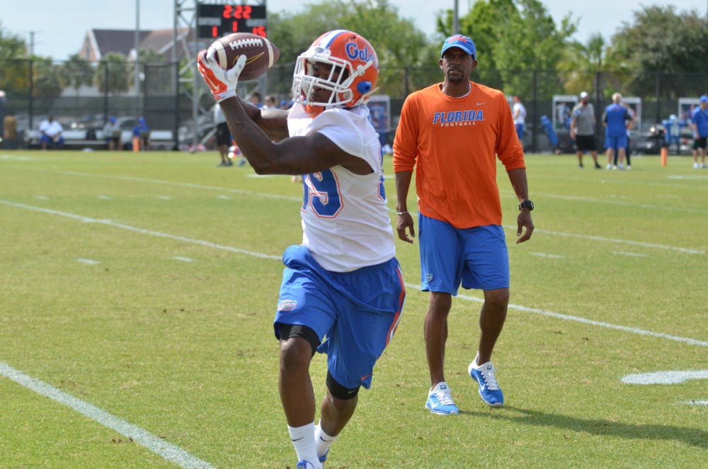 Wide receiver Alvin Bailey catches a pass during Spring practice on April 6 while wide receivers coach Kerry Dixon looks on at Donald R. Dizney Stadium.