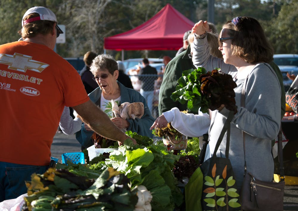 <p>Rana Hyder, 42, right, waits to purchase vegetables from Jones Family Farms Saturday at the Alachua County Farmers Market,  at 5920 NW 13th St. The market offers Fresh Access Bucks that make it easier for Supplemental Nutrition Assistance Program recipients to purchase local produce.</p>