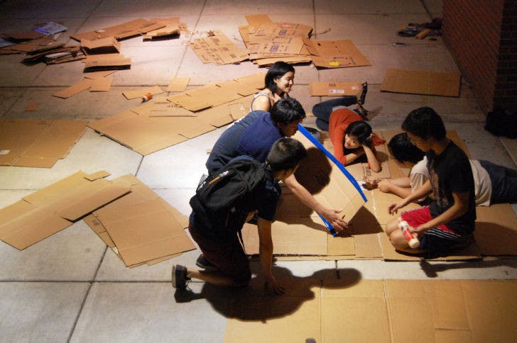 Members of UF’s Asian American Student Union prepare cardboard mats in the Reitz Union breezeway Wednesday evening for the Cardboard Ox activity, which was held during the AASU Field Day on Monday.