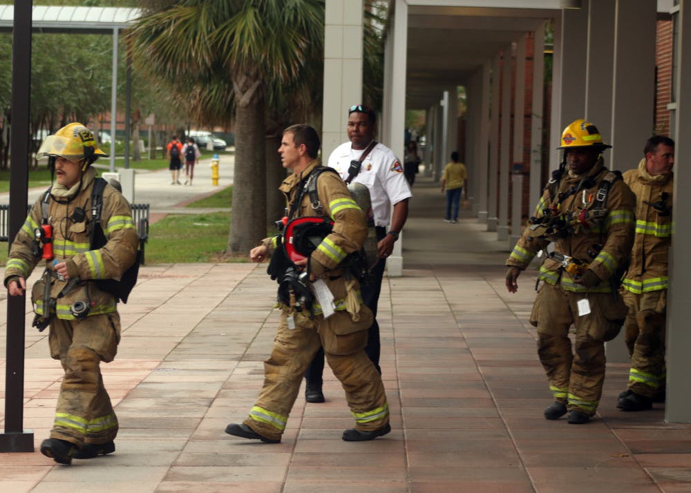 Gainesville Fire Rescue firefighters come out of the Biomedical Sciences Building in bunker gear after assessing the chemical spill on Monday, Nov. 5, 2018. The spill was contained within the fume hood and the hazmat team determined that the room was safe. 