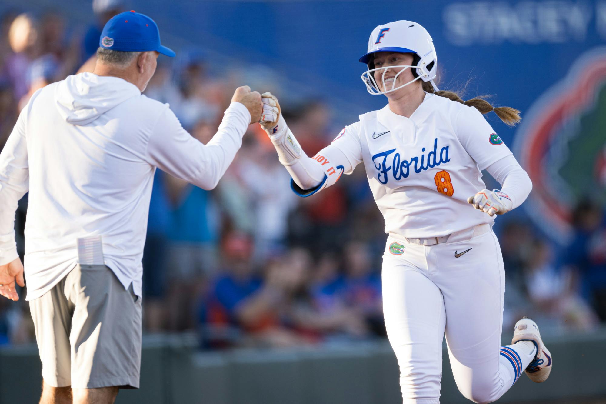Florida Gators catcher Jocelyn Erickson (8) fist bumps head coach Tim Walton after a home run in a softball game against UCF in Gainesville, Fla., on Wednesday, March 12, 2025.