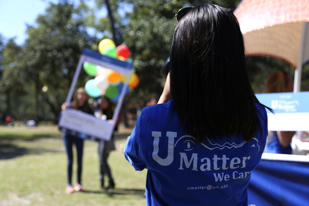 Kasey Tahmosh, a 20-year-old UF marketing sophomore, takes a picture of two students with an Instagram photo frame with the #UpLiftUF on the Plaza of the Americas for the U Matter Day on Tuesday.
