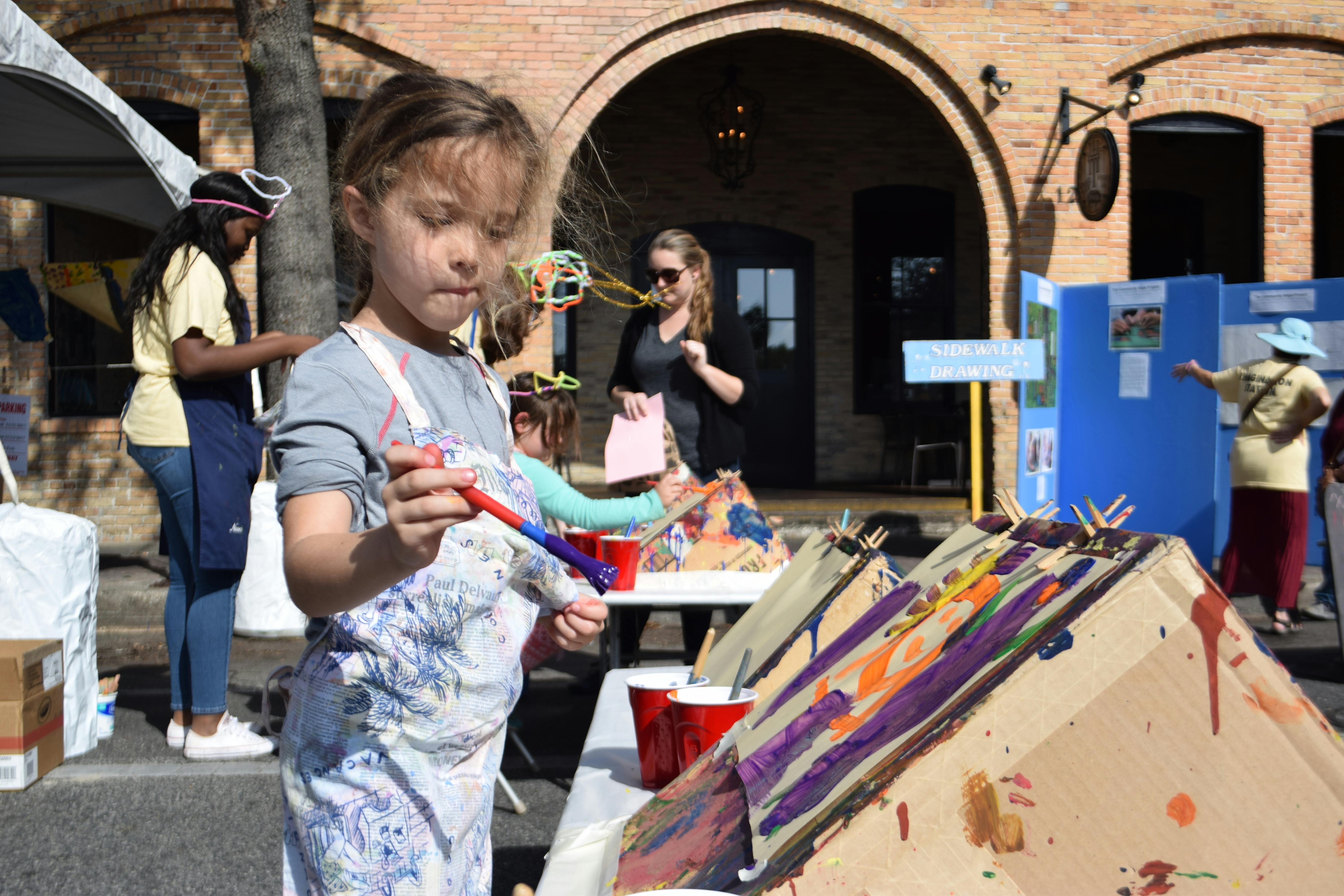 Sofia Otero, 6, works on her painting alongside other children at the 36th annual Downtown Festival &amp; Art Show on Saturday. 