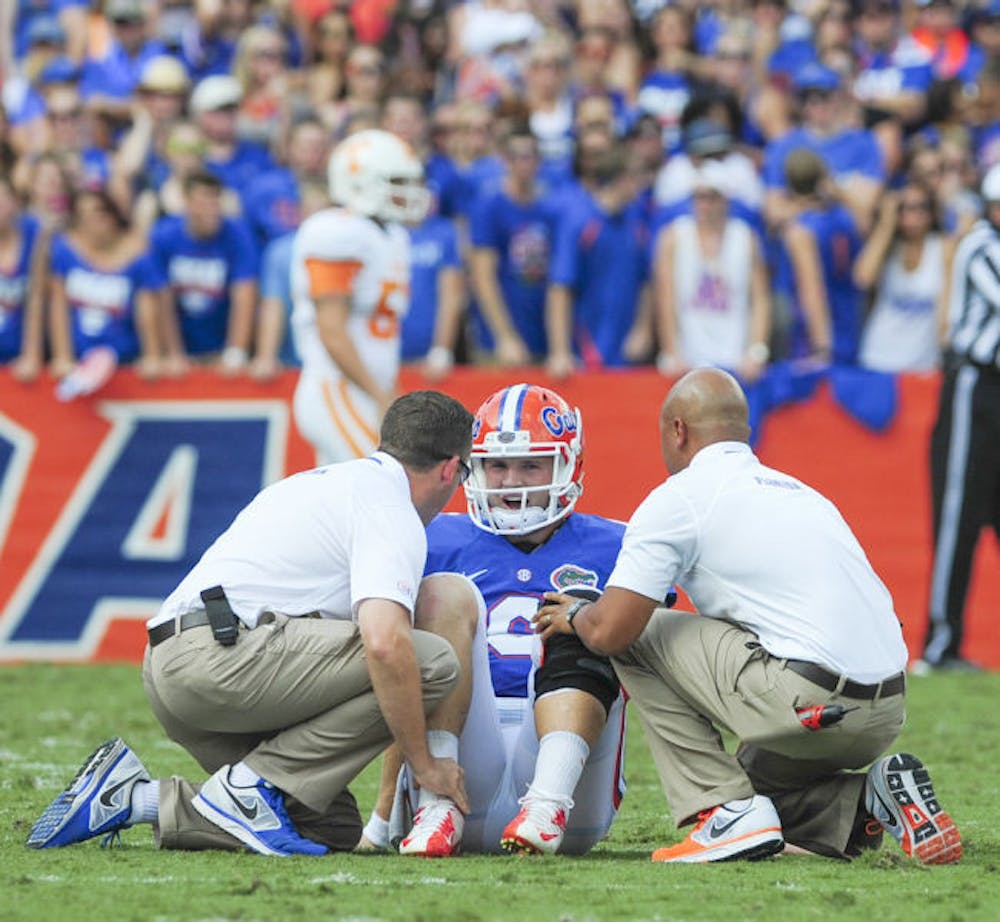 <p>Two trainers attend to quarterback Jeff Driskel after he suffered a fractured right fibula during Florida’s 31-17 victory against Tennessee on Saturday in Ben Hill Griffin Stadium.</p>
