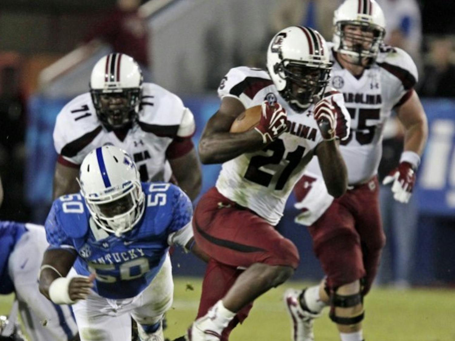 South Carolina tailback Marcus Lattimore (21) runs away from Kentucky's Mike Douglas (50) during the second half of an NCAA college football game in Lexington, Ky., on Sept. 29. Then No. 6 South Carolina came from behind to beat Kentucky 38-17.