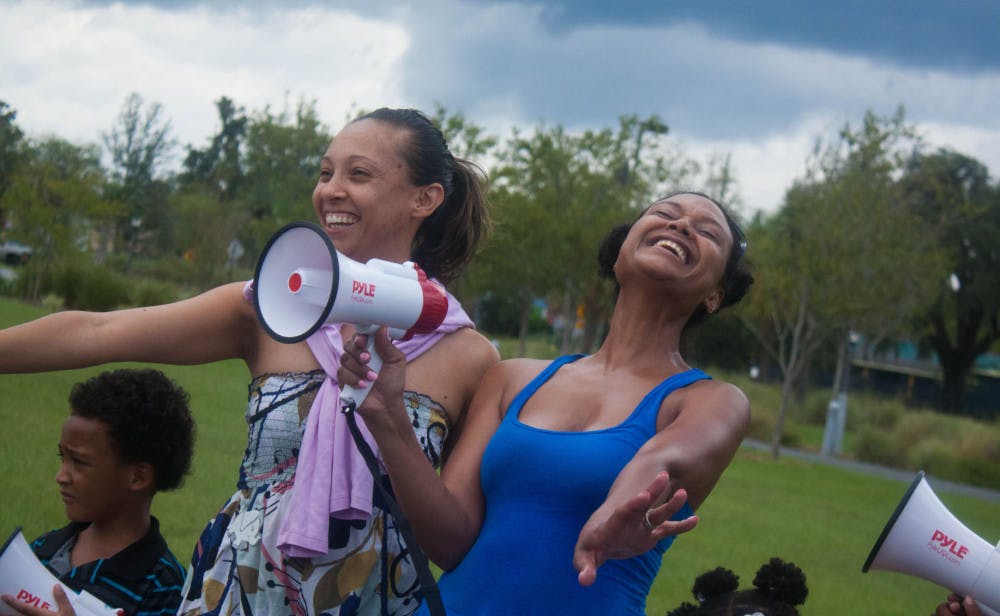 Friends Keisha Roberts and Staci Bertrand participated in the competition for the best “save the elephant and rhino” chant or song. Together, they sang their protest song as their children joined them.