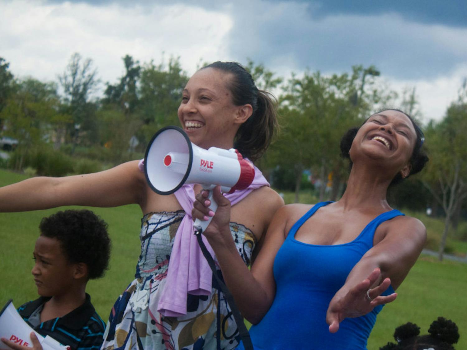 Friends Keisha Roberts and Staci Bertrand participated in the competition for the best “save the elephant and rhino” chant or song. Together, they sang their protest song as their children joined them.