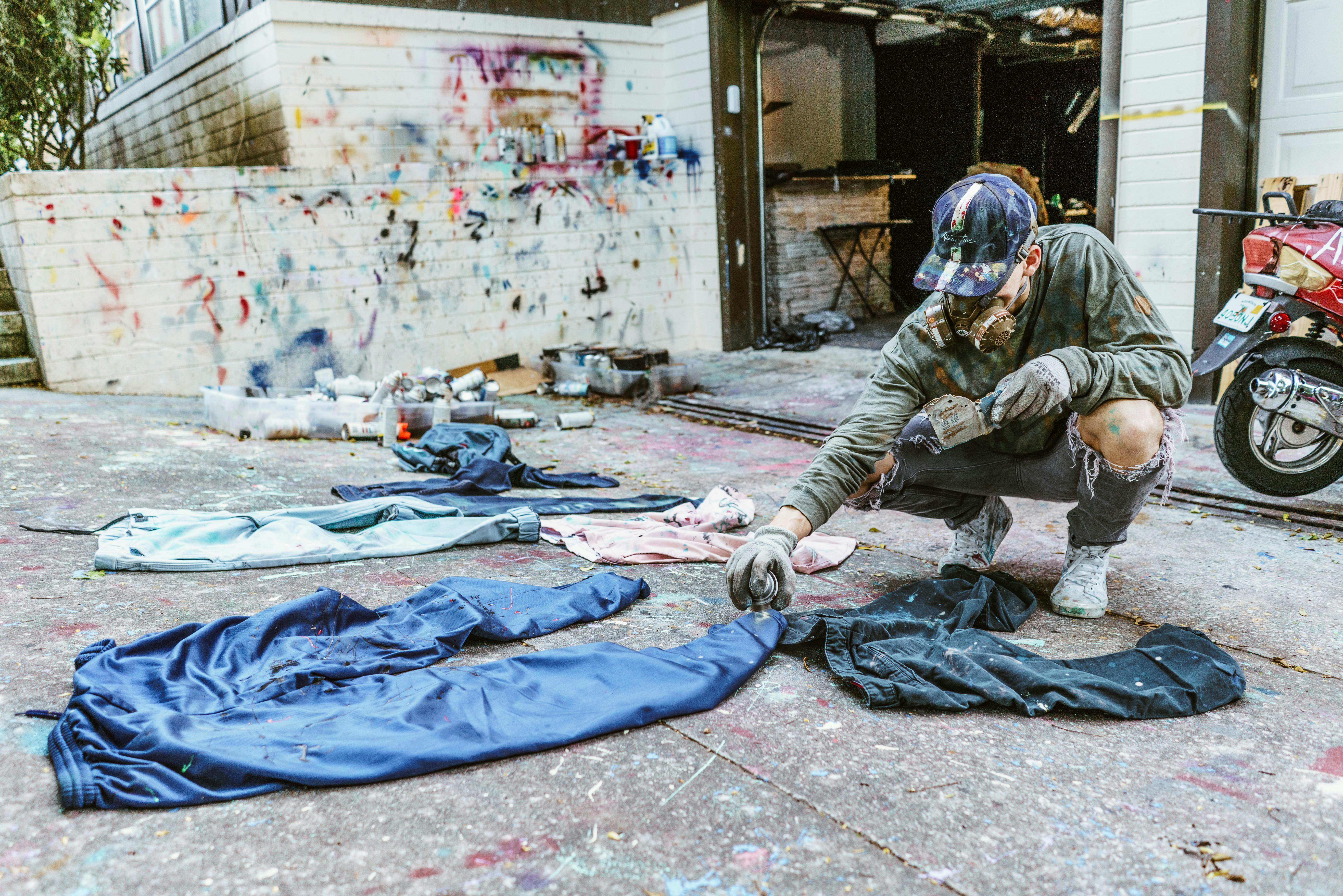 Always True Collective CEO Drew Howard spray paints clothes in preparation for Friday’s show.