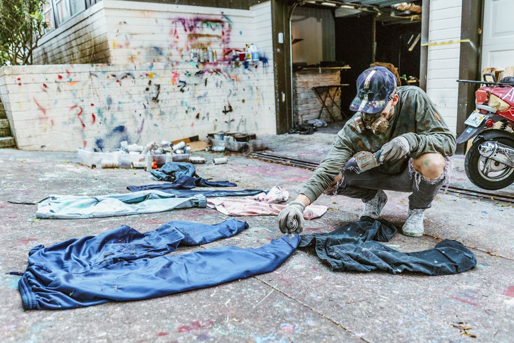 <p><span id="docs-internal-guid-14314a2b-d6c8-7e9a-2d8b-f0ee17c6327a"><span>Always True Collective CEO Drew Howard spray paints clothes in preparation for Friday’s show.</span></span></p>