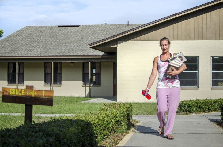 Myrtle Belflower, 27, pick up books from&nbsp; Grace Marketplace’s library on Wednesday. The homeless center opened Sunday and offers free meals twice a day. Several facilities are open to visitors.