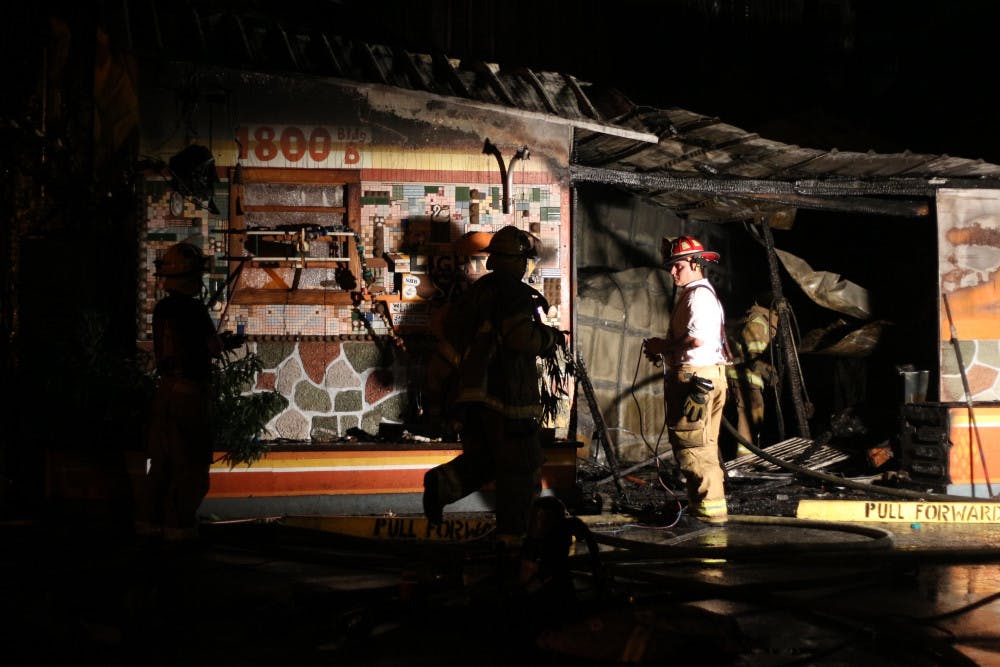 A fireman stands in the frame of what was Lightning Salvage, shop at the back of Satchel's Pizza.