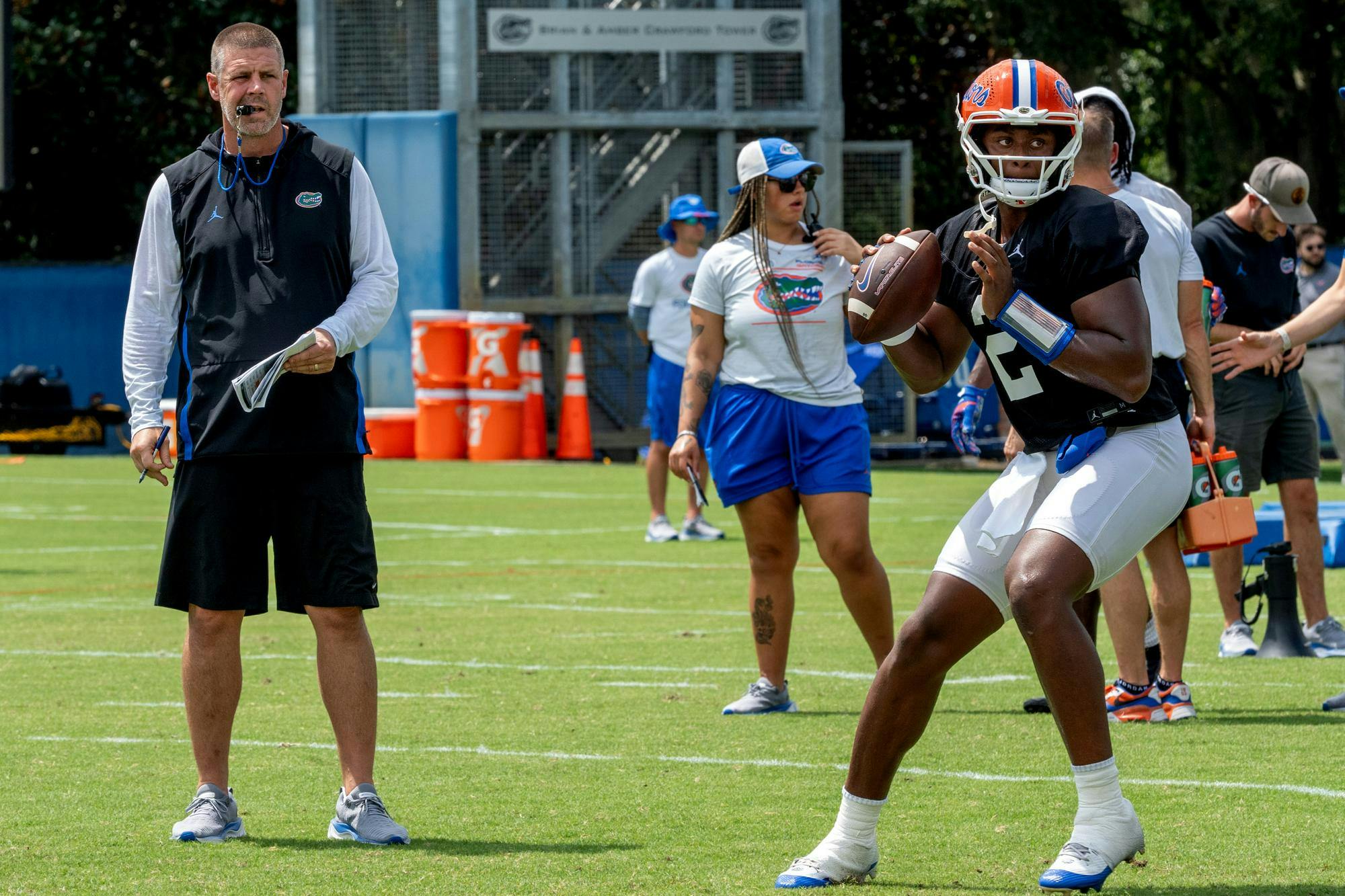 UF Football Coach Billy Napier looks on as Quarterback DJ Lagway passes the ball during a spring practice session.