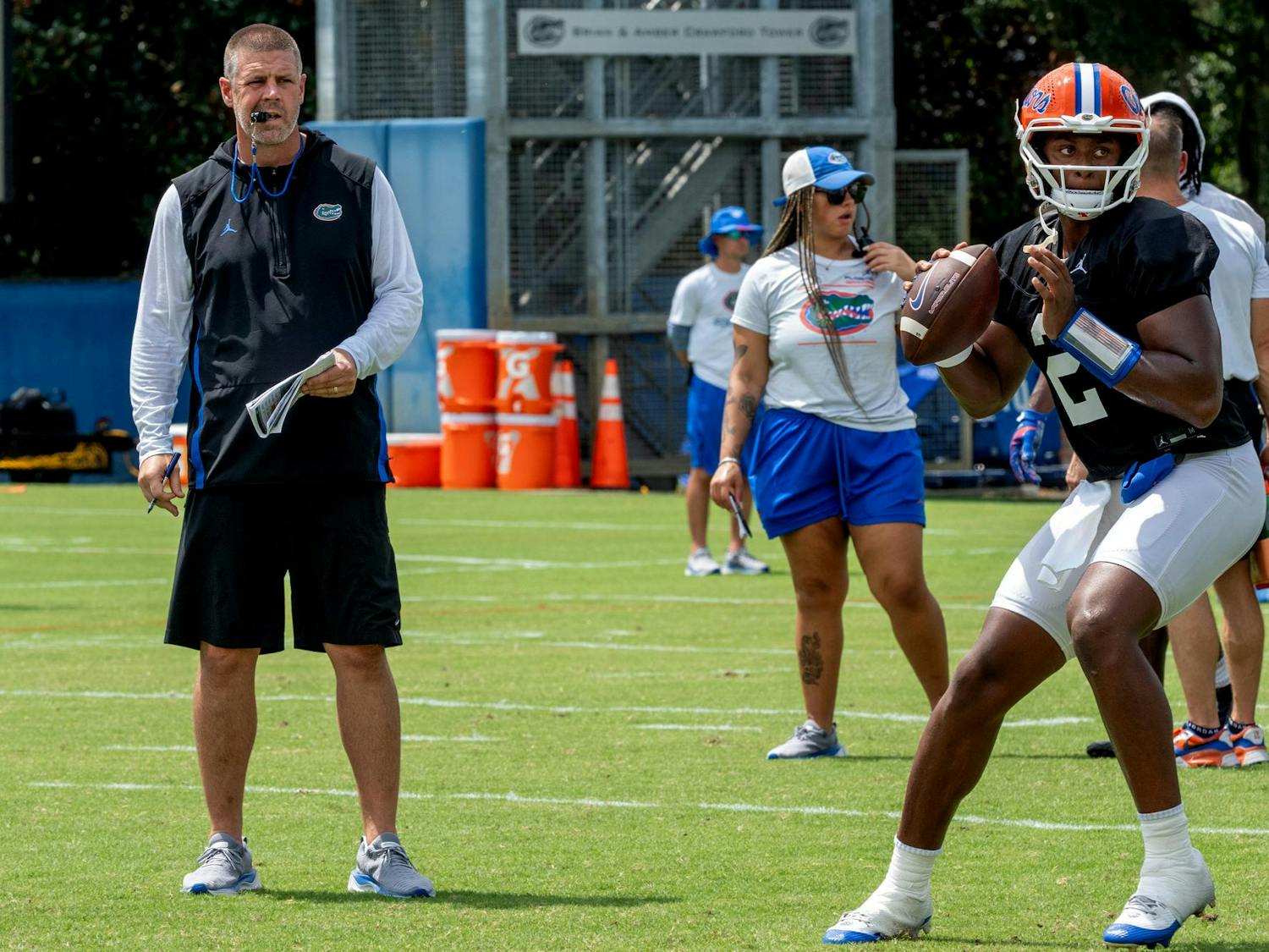 UF Football Coach Billy Napier looks on as Quarterback DJ Lagway passes the ball during a spring practice session.