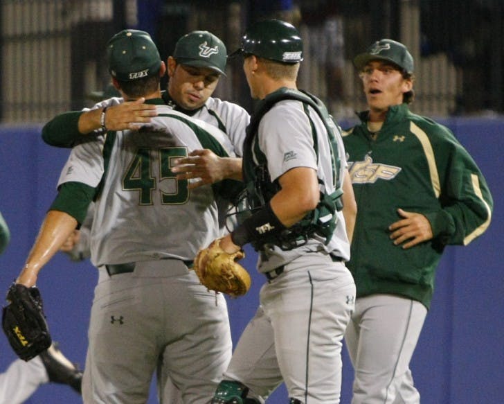 South Florida relief pitcher Steven Leasure (45) receives an embrace from teammates after clinching a 5-3 win against Florida on Tuesday. The midweek loss was just the Gators’ second this season.