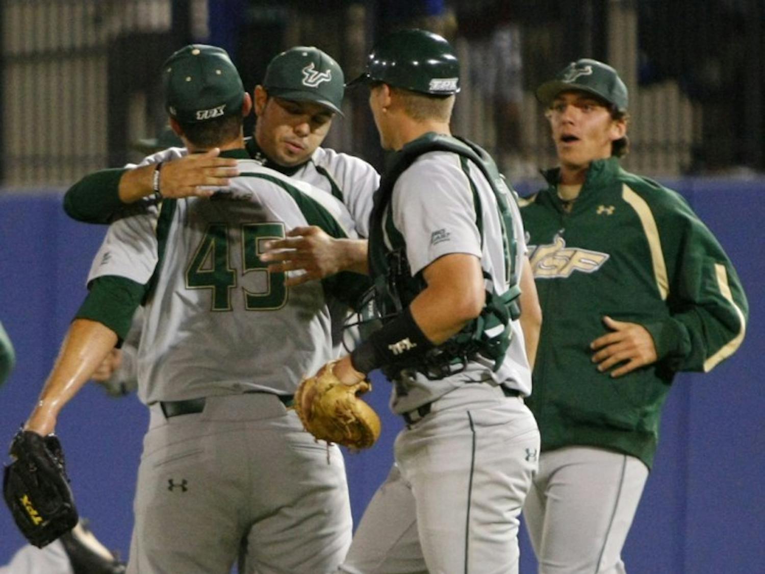 South Florida relief pitcher Steven Leasure (45) receives an embrace from teammates after clinching a 5-3 win against Florida on Tuesday. The midweek loss was just the Gators’ second this season.
