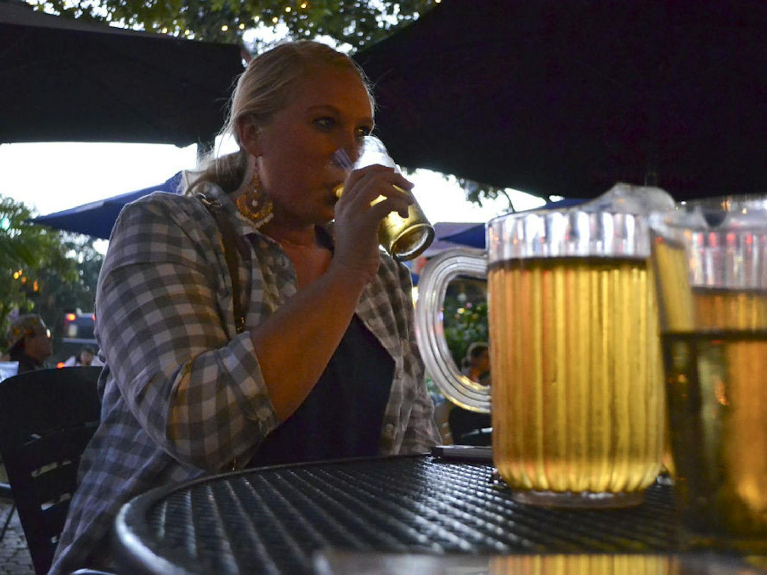 Mary Myers, a 22-year-old UF family, youth and community sciences senior, sips from her beer at The Swamp Restaurant on Oct. 13, 2015. Myers said when game day rolls around she comes to the restaurant with her friends because it has a fun outside atmosphere.