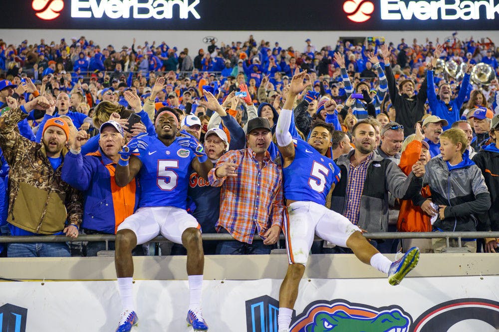 <p>Florida wide receiver Ahmad Fulwood (left) and defensive back Jalen Tabor (5) celebrate with fans following UF's 38-20 win against UGA on Saturday at EverBank Field in Jacksonville.</p>